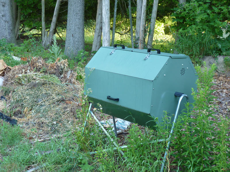 Composting area with tumbler (for food waste) and piles (for weeds/yard waste/leaves)