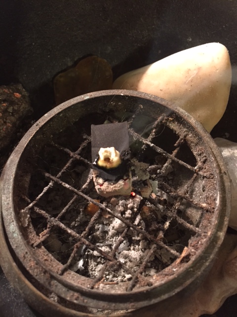 Burning a small amount of red pine resin on a charcoal block in a censer