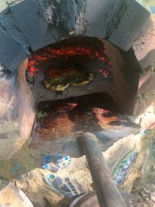 Pizza peel in action! - Getting ready to pull flatbread out of the oven--this oven is about 800-900 degrees with active coals!