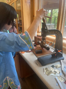 Daphne (in my class) stamps her book cover with a gilding machine to put on a title