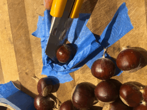 Chestnut jig to save your fingers - masking tape and a piece of cardboard on a cutting board